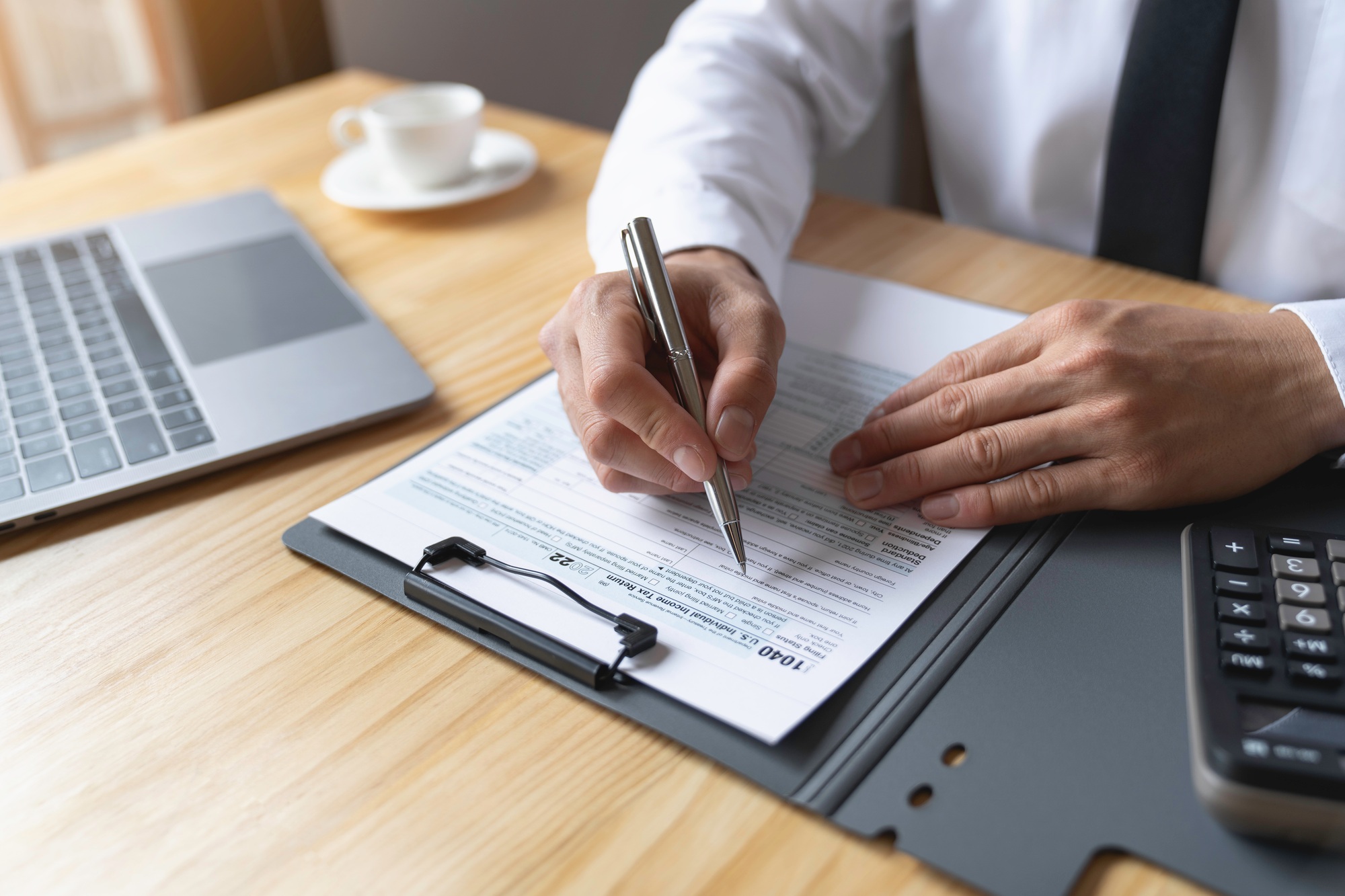 Individual Tax Return Forms on the table, An accountant working with US tax forms, Accountant calcul