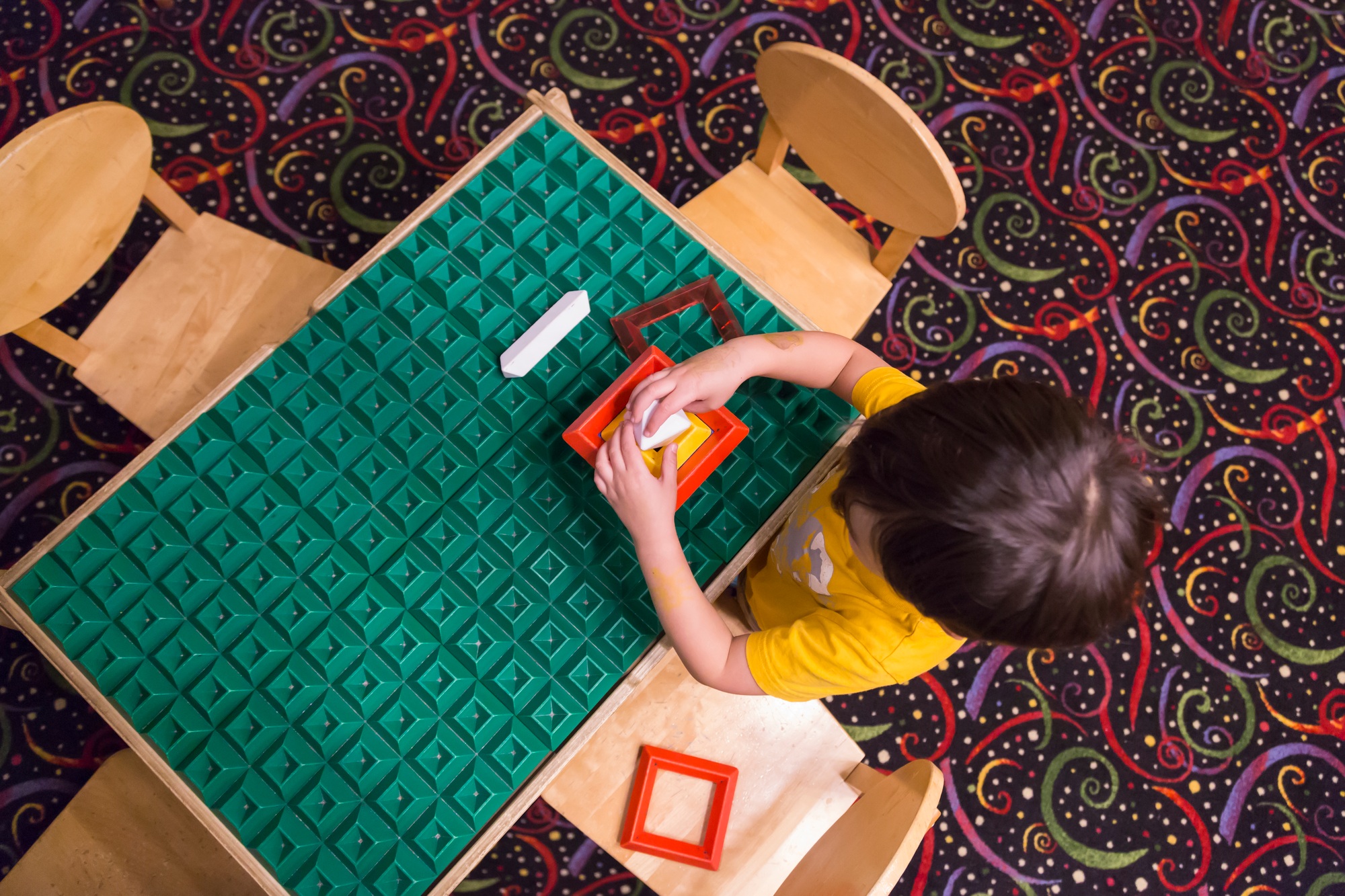 Overhead of Boy Playing With His Toys at Table