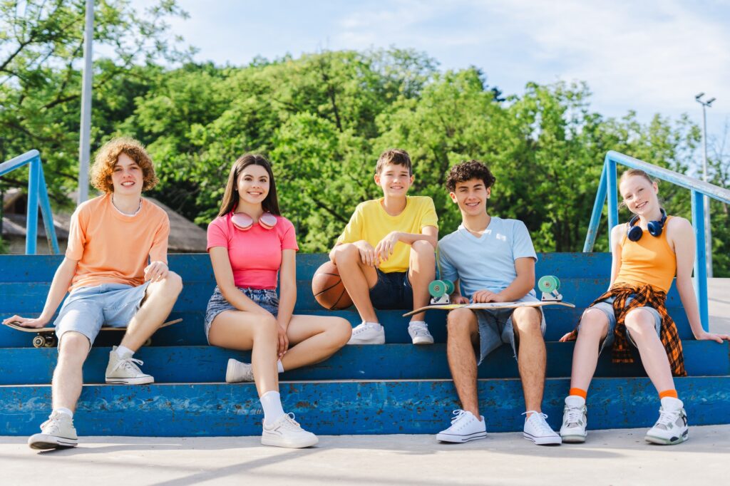 Happy stylish boys and girls on street looking at camera