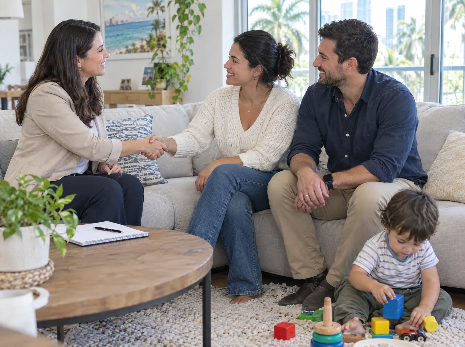 A behavior analyst shakes hands with parents on their sofa during a first consultation