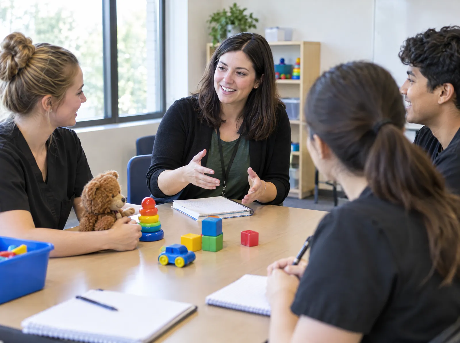 A clinical trainer leads new behavior technicians through a role-play in a training room