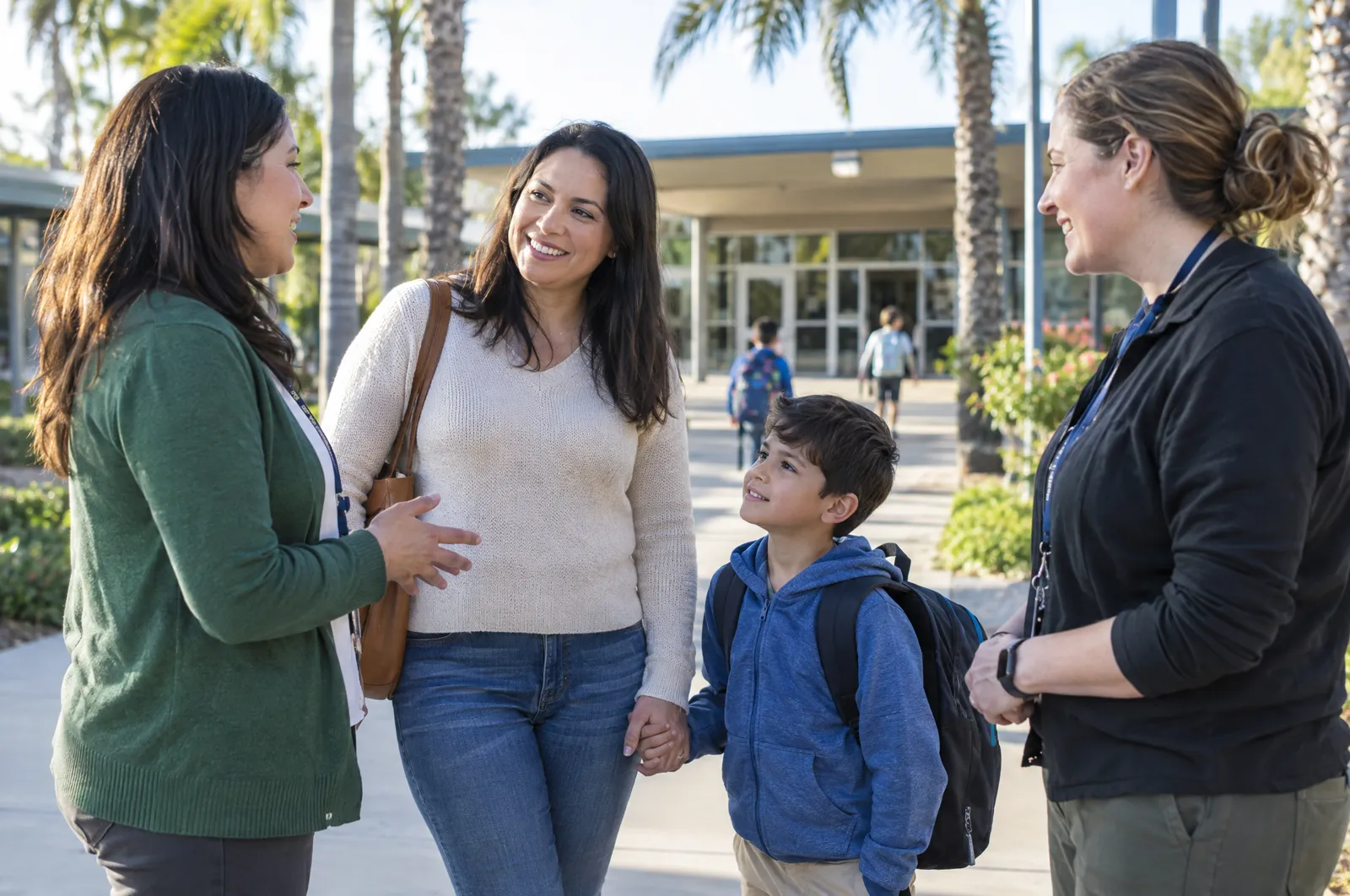 A teacher, a mother and a therapist talk at the school entrance