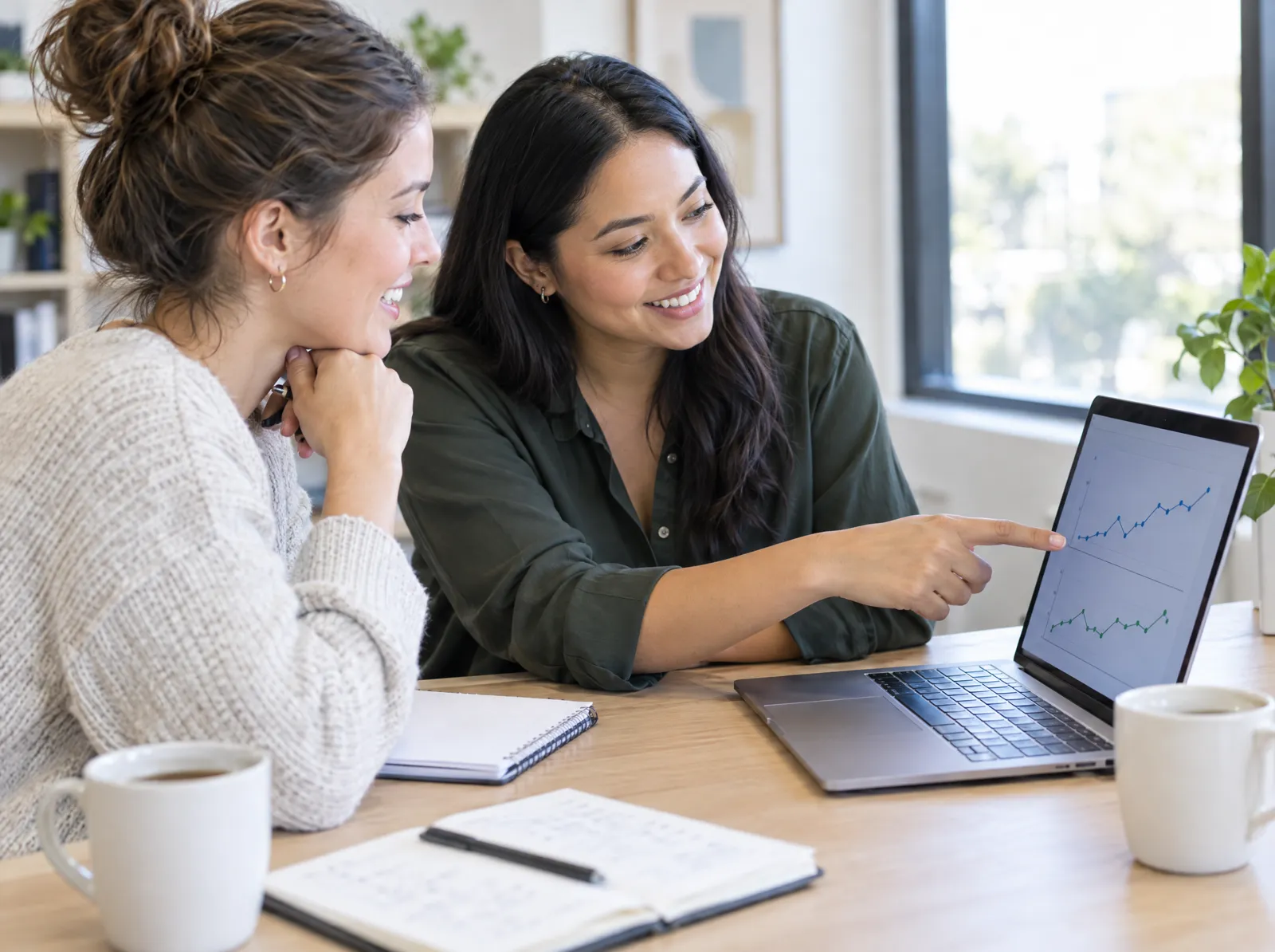 Two behavior analysts review progress graphs on a laptop
